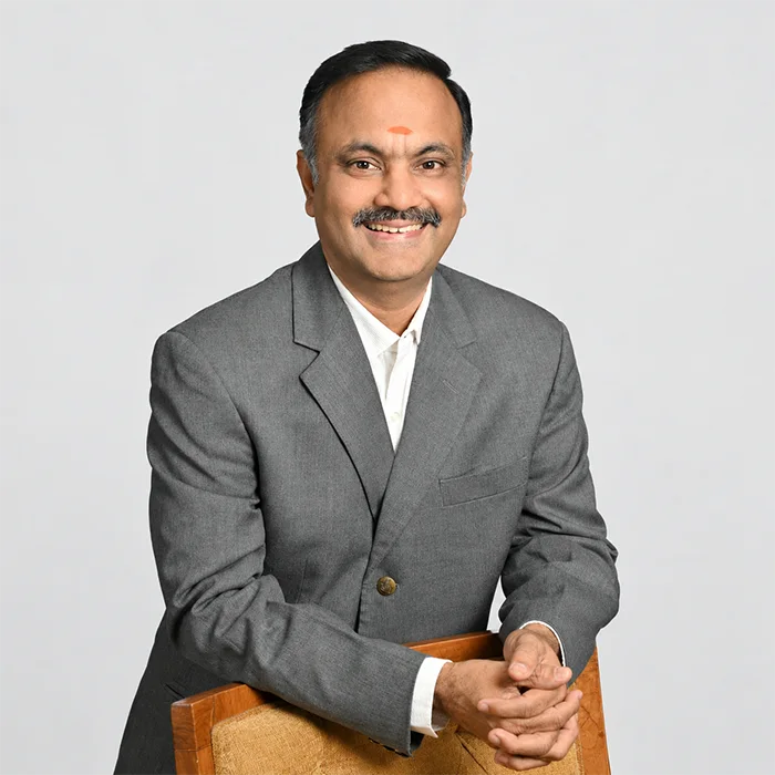 Sriram K, founder of Pranaya Weddings and wedding planner in Chennai, smiling in a grey blazer